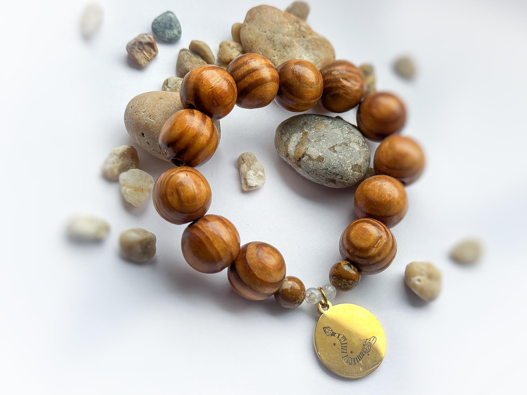 6a1adf4a-f6ee-4bab-bcf9-ad626087d77f Bransoletka z Drewna z przywieszką w odcieniu złotym z rysunkiem Beaty Pawlikowskiej Wąż Quetzalcoatl - obrazek 1