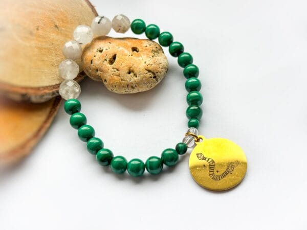 Bransoletka z malachitu i kryształu górskiego  z przywieszką rysunkiem Beaty Pawlikowskiej Wąż Quetzalcoatl